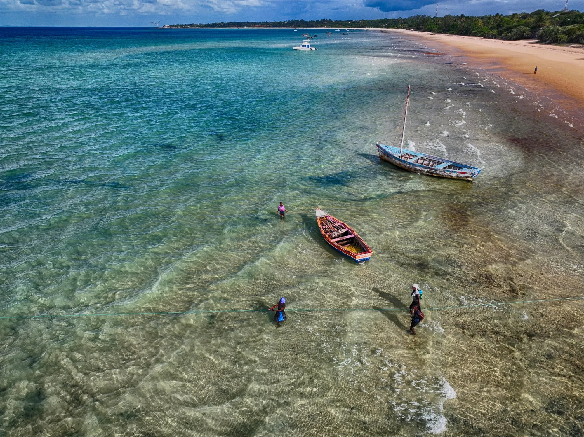 Fishing boats and swimmers in the turquoise shallows at Vilankulo