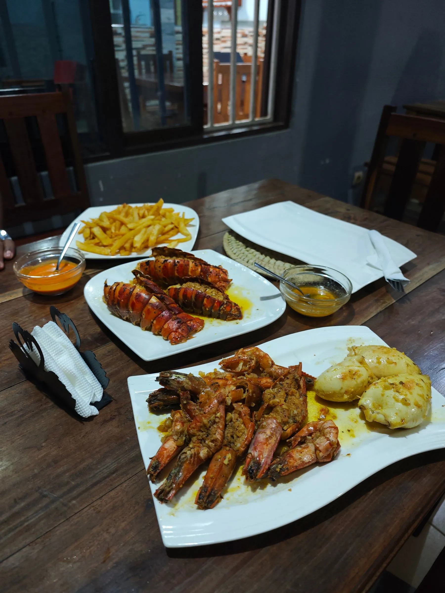 Grilled lobster tails with garlic prawns and chips for dinner at Residencial Duma